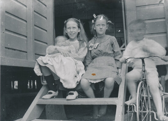 Group of four children including Edna and Horace Wooster, sitting on back steps