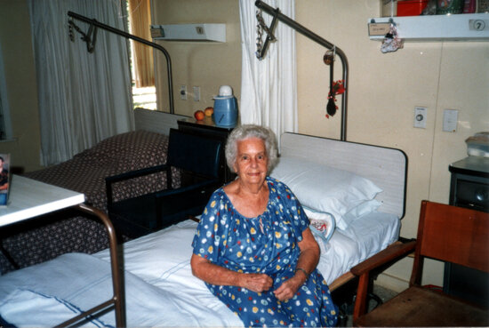 Ethel Sellars sitting on a bed in a Ward at Eventide