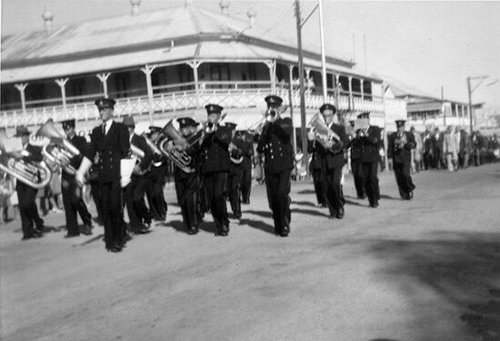 Excelsior Band marching past the Excelsior Hotel
