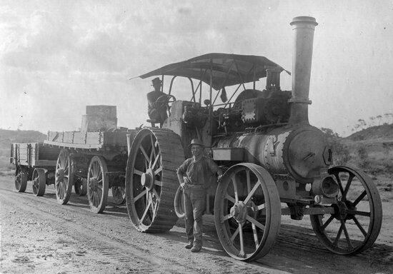 Steam engine tractor pulling two wagons