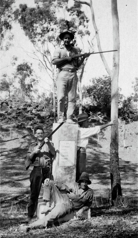Four men with rifles beside Leichhardt Memorial
