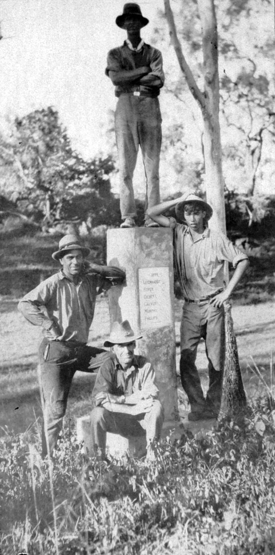 Four men beside Leichhardt Memorial