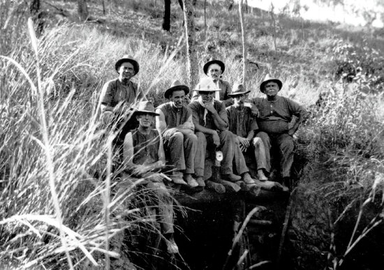 Miners sitting at top of mine shaft in the bush