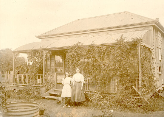 Woman and girl standing outside a Miner&rsquo;s Cottage
