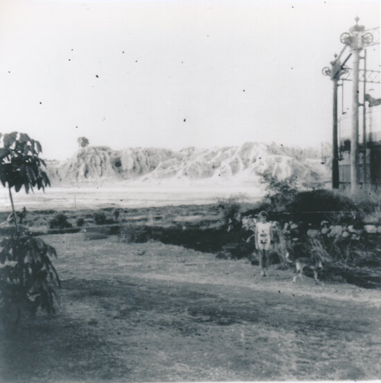 Child standing near Gas Works, Boundary st with Cyanide Heaps in background