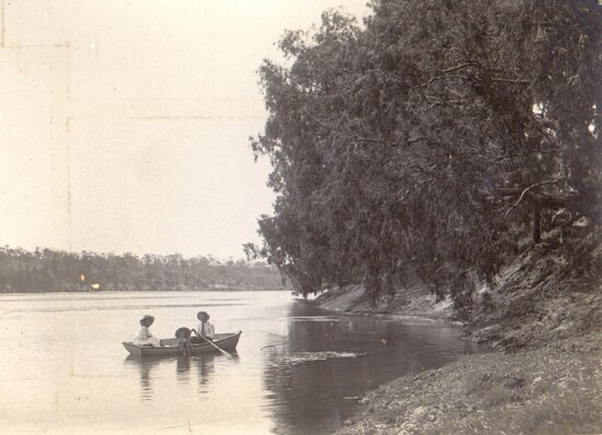 Man, woman and child in a row boat on a river