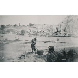 Man working at washing for gold, near a Tailings Heap
