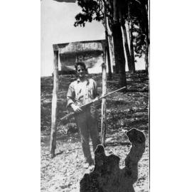 Man with rifle beside Leichhardt Marker