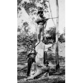 Four men with rifles beside Leichhardt Memorial