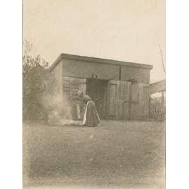 Unknown Woman raking and burning leaves