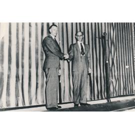 Mayor J D Cunningham shaking hands with Len Leahy on the stage of the Theatre Royal