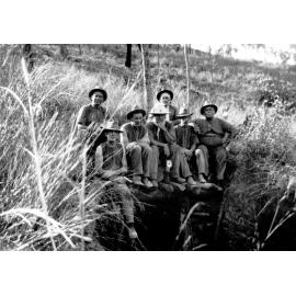 Miners sitting at top of mine shaft in the bush