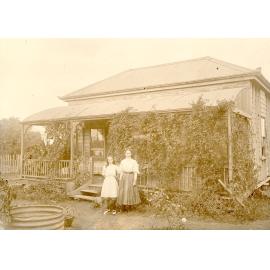 Woman and girl standing outside a Miner’s Cottage