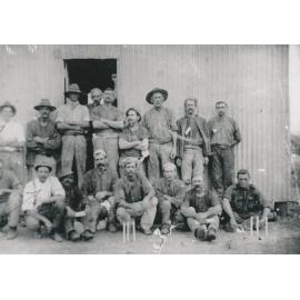 Miners in front of a tin shed with candles