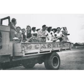 Group on the way to a bush picnic in back of a truck