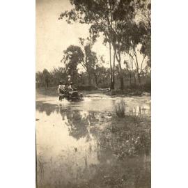Motor car crossing a river ford