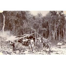 Men in a forest campsite