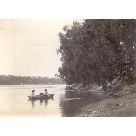 Man, woman and child in a row boat on a river
