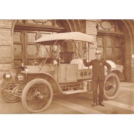 Algernon Pilcher in Ambulance uniform beside an early model Ambulance vehicle, Q.A.T.B Head Centre, Brisbane
