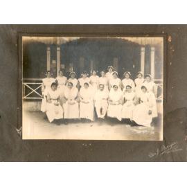 Doctor with Nurses outside timber building