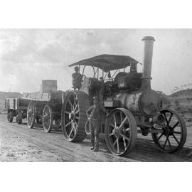 Steam engine tractor pulling two wagons