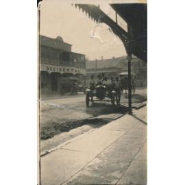 Motor Car arriving outside Ben Toll Building, Gill Street with horse drawn vehicle in background