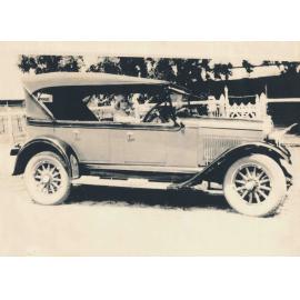 Ethel Roberts seated at car steering wheel, outside the Family Home, Boundary Street
