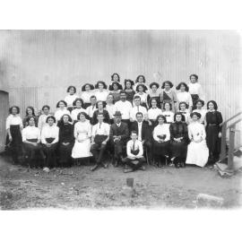 Group of Men, Women and Children in Front of Shed