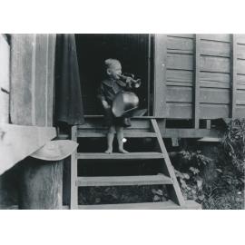 Horace Meredith Wooster on back stairs playing musical instruments