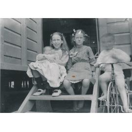 Group of four children including Edna and Horace Wooster, sitting on back steps