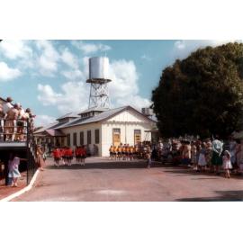 Students marching past the Eventide Kitchen Block & Reserve Emergency Water Tower