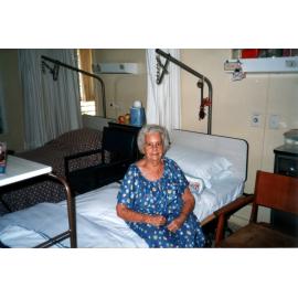 Ethel Sellars sitting on a bed in a Ward at Eventide